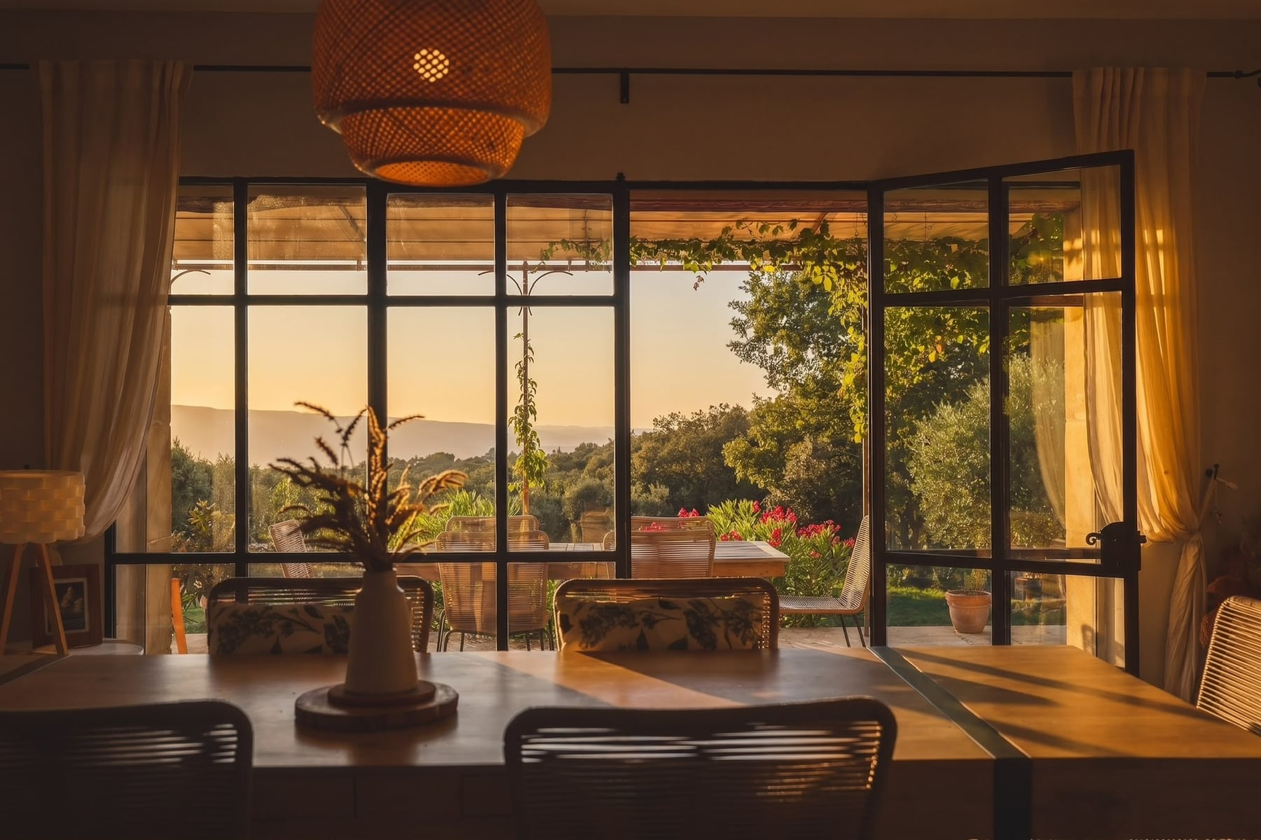 La grande table, la baie vitrée et la vue sur le Luberon au couchant